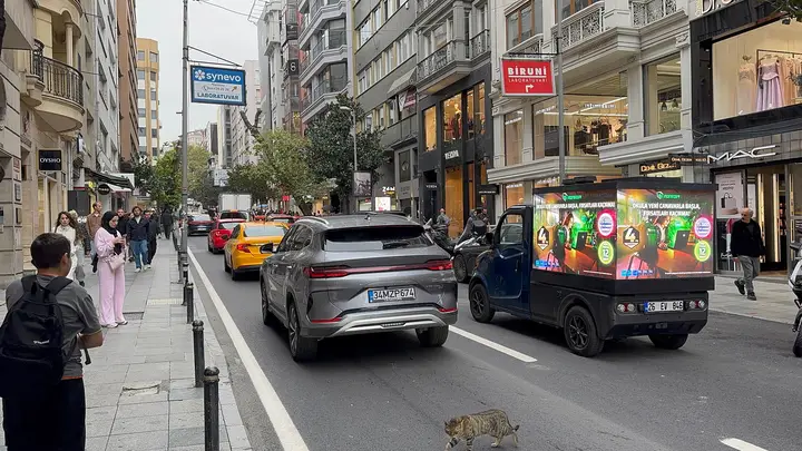 Nişantaşı'nda yayaların arasından geçen LED araç
